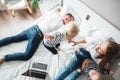 Happy family sits on bed with children using the computer together at home Royalty Free Stock Photo