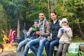 Happy family sitting on bench at camp fire Royalty Free Stock Photo