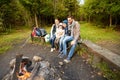 Happy family sitting on bench at camp fire Royalty Free Stock Photo