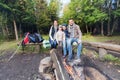 Happy family sitting on bench at camp fire Royalty Free Stock Photo