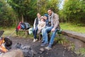 Happy family sitting on bench at camp fire Royalty Free Stock Photo