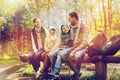 Happy family sitting on bench and talking at camp Royalty Free Stock Photo