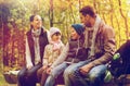 Happy family sitting on bench and talking at camp Royalty Free Stock Photo