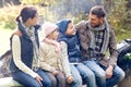 Happy family sitting on bench and talking at camp Royalty Free Stock Photo