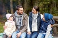 Happy family sitting on bench and talking at camp Royalty Free Stock Photo