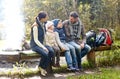 Happy family sitting on bench and talking at camp Royalty Free Stock Photo