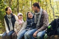 Happy family sitting on bench and talking at camp Royalty Free Stock Photo