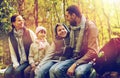 Happy family sitting on bench and talking at camp Royalty Free Stock Photo