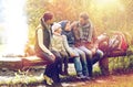 Happy family sitting on bench and talking at camp Royalty Free Stock Photo