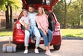 Happy family sitting in car`s trunk Royalty Free Stock Photo