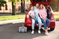 Happy family sitting in car`s trunk Royalty Free Stock Photo