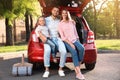 Happy family sitting in car`s trunk Royalty Free Stock Photo