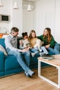 Happy family sitting on couch, adopted sisters playing stuffed toys