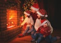 Happy family sitting by fireplace on Christmas Eve Royalty Free Stock Photo