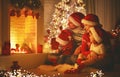 Happy family sitting by fireplace on Christmas Eve Royalty Free Stock Photo