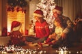 Happy family sitting by fireplace on Christmas Eve Royalty Free Stock Photo