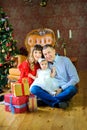 Happy family sitting on the floor near boxes with gifts and smiling Royalty Free Stock Photo