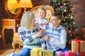 Happy family sitting on the floor near the Christmas tree Royalty Free Stock Photo