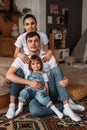 Happy family sitting on floor with their little baby. Family spending time at home with their daughter. Happy young family. Royalty Free Stock Photo