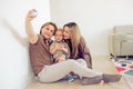 Happy family sitting on floor with their little baby. Family spending time at home with their son. Father holding the ball Royalty Free Stock Photo