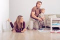 Happy family sitting on floor with their little baby. Family spending time at home with their son Royalty Free Stock Photo