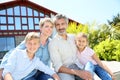 Happy family sitting in font of their home Royalty Free Stock Photo