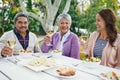 Happy family and sitting with food or lunch together outside for celebration on summer vacation or holiday. Parents and Royalty Free Stock Photo