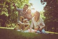 Happy family sitting on grass in the meadow together and enjoyin Royalty Free Stock Photo