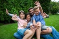 Happy family sitting on grass in park on a sunny day Royalty Free Stock Photo