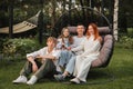 A happy family is sitting in a hammock on the lawn near the house Royalty Free Stock Photo