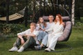 A happy family is sitting in a hammock on the lawn near the house Royalty Free Stock Photo