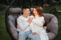 A happy family is sitting in a hammock on the lawn near the house Royalty Free Stock Photo