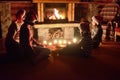 Happy family sitting near fireplace and celebrating Christmas and New Year, parents and children in Santa hats Royalty Free Stock Photo