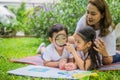 A happy family sitting and reading a book in the garden Royalty Free Stock Photo