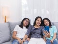 Happy family sitting on sofa in living room speak with someone on mobile phone together, smiling mother showing cute little child Royalty Free Stock Photo