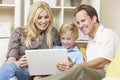 Happy Family Sitting on Sofa Using Laptop Computer Royalty Free Stock Photo