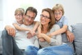 Happy family sitting on sofa wearing eyeglasses