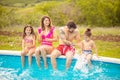 Family sitting by the swimming pool Royalty Free Stock Photo