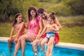 Happy family sitting by the swimming pool Royalty Free Stock Photo