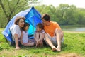 Happy family sitting in tent on lawn Royalty Free Stock Photo