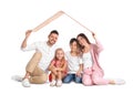 Happy family sitting under cardboard roof on background. Insurance concept