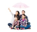 Happy family sitting under an umbrella Royalty Free Stock Photo