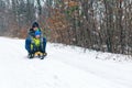 Happy family with sled in winter having fun together. Child sledding.Happy mother and her son enjoying sleigh ride. Family driving Royalty Free Stock Photo