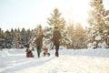 Happy family sledding in the park in winter.