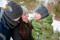 Happy family with a small child in winter in the park. The mother holds the baby in her arms. Royalty Free Stock Photo