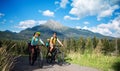 Family with small children cycling outdoors in summer nature.