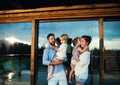 Family with small children standing by wooden cabin, holiday in nature concept. Royalty Free Stock Photo