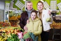 Happy family with small daughter standing with full grocery cart Royalty Free Stock Photo