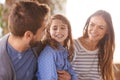Happy family, smile and love outdoor hugging for summer, sunshine and vacation. Father, mother and daughter in morning Royalty Free Stock Photo