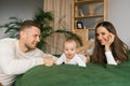 Family with smiles and a baby are lying and resting on the bed Royalty Free Stock Photo